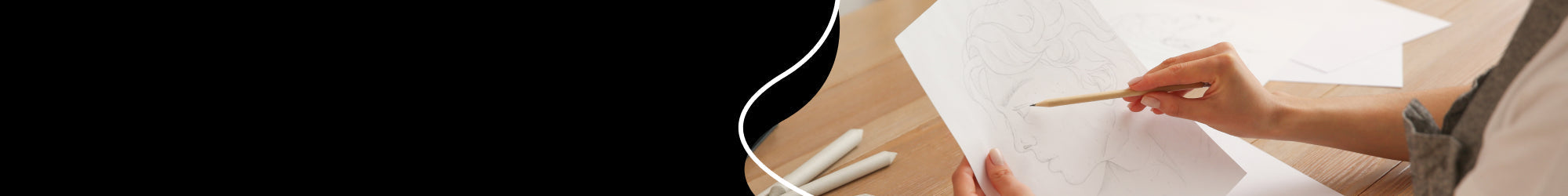 Hand holding a pencil, drawing on a drawing sheet